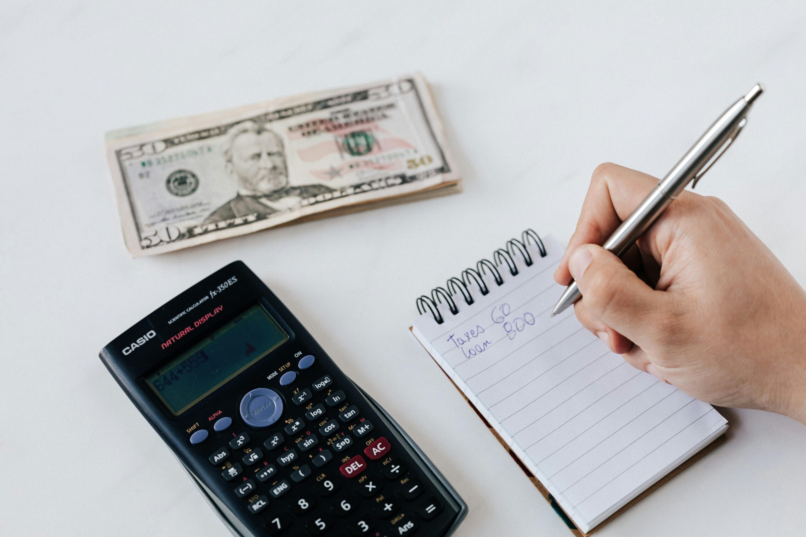 Person writing budget and financial plan in notebook — recovery tips after loan app crisis India