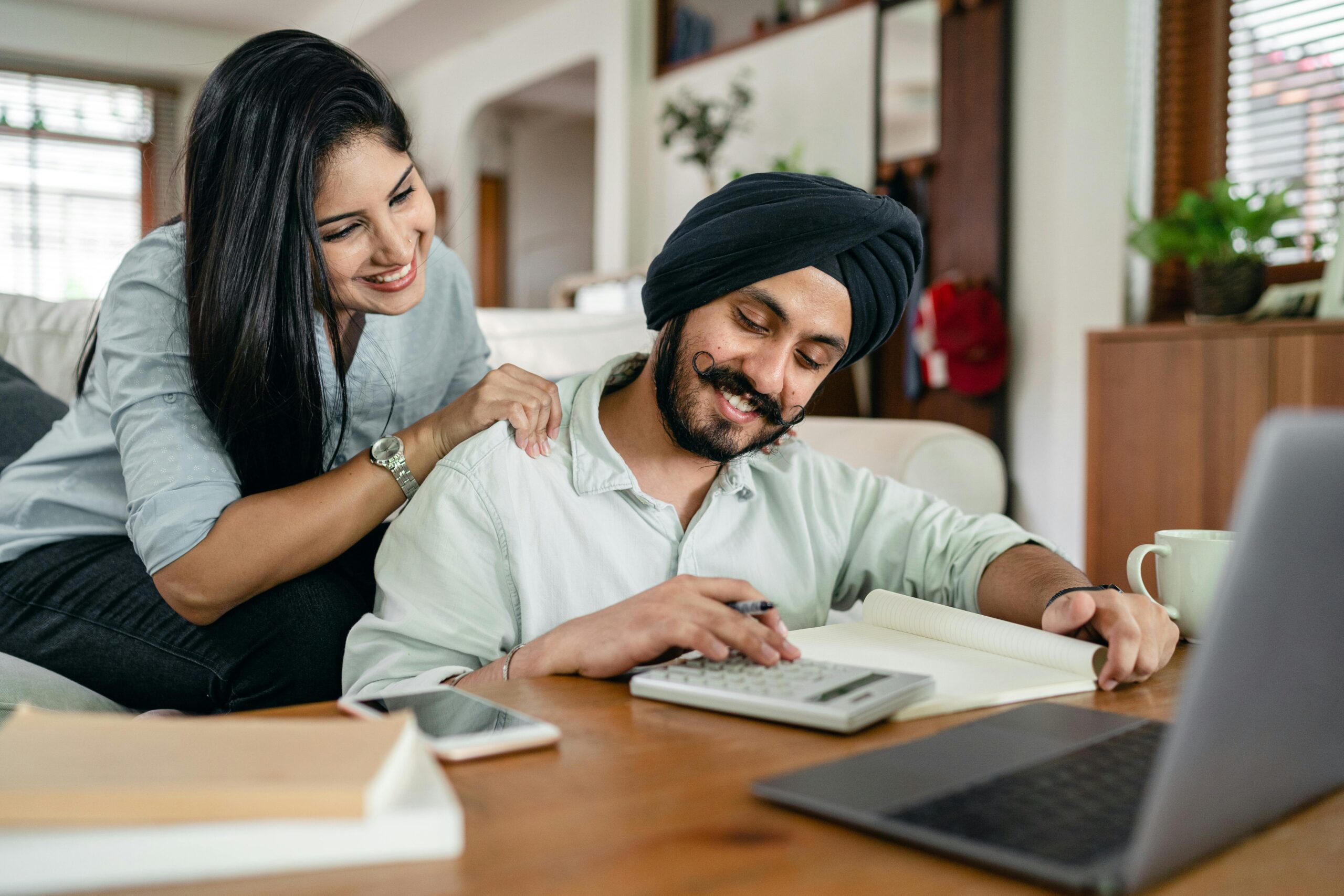 Indian couple happy reviewing improved CIBIL score and financial plan at home
