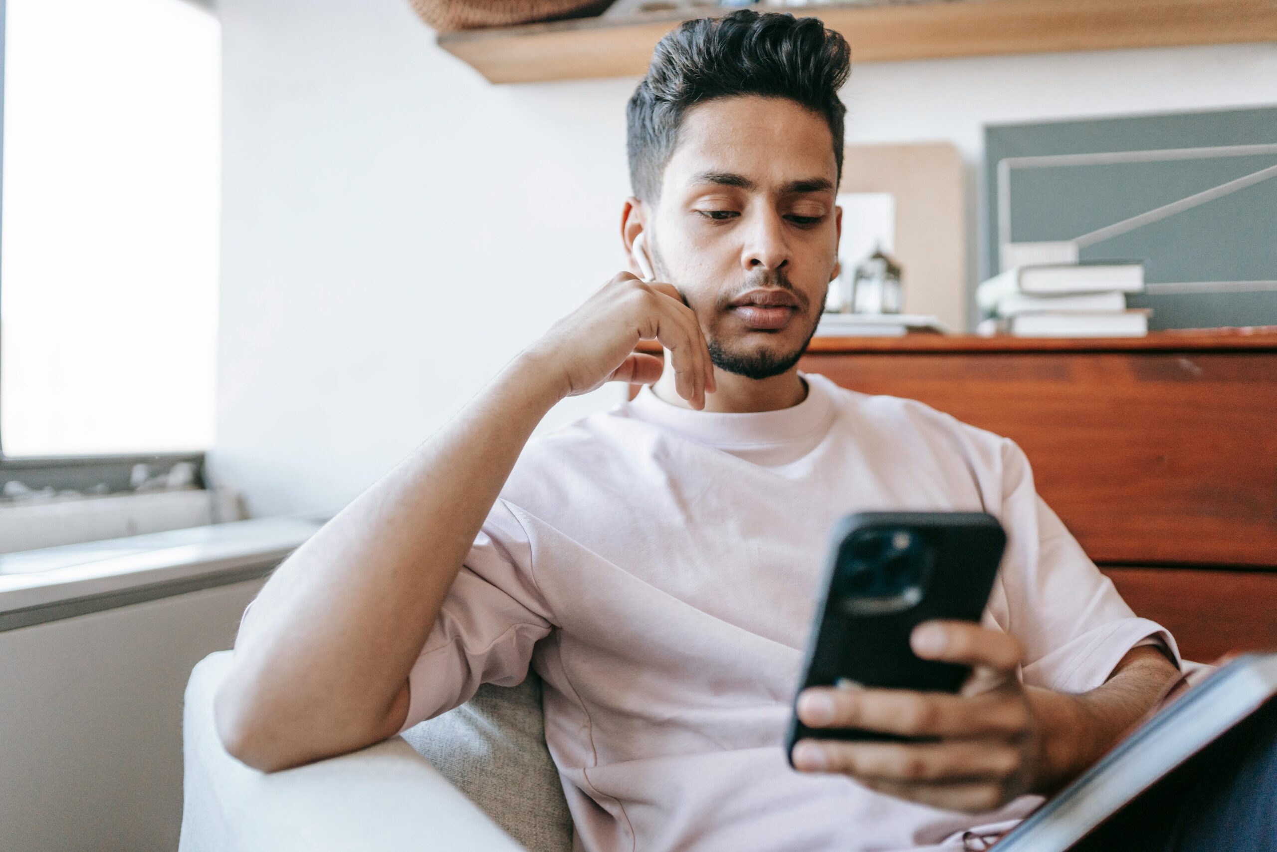 Indian man carefully reviewing loan app on smartphone before applying — verifying RBI registration