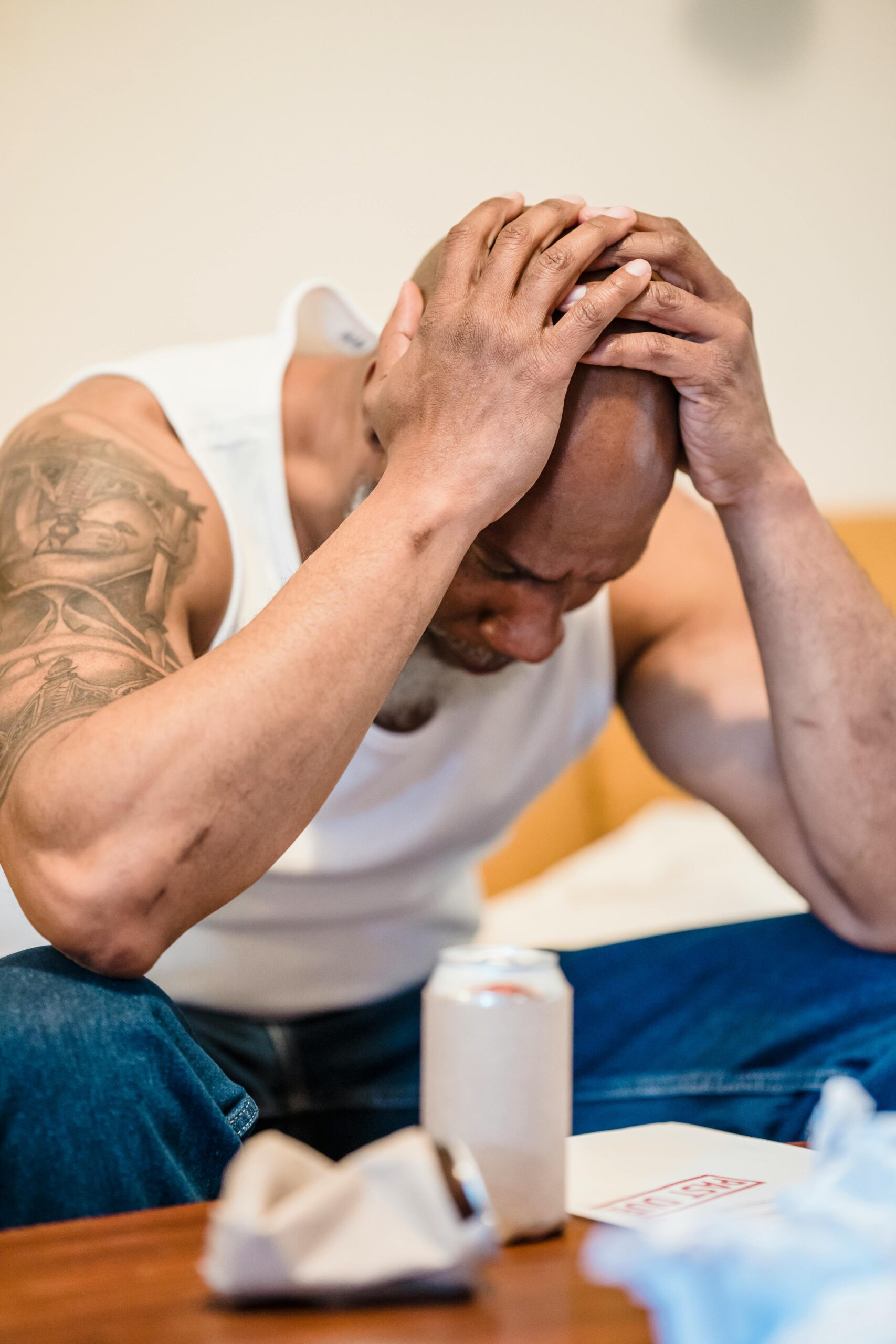 Man stressed holding head in hands after loan app harassment and contact shaming in India