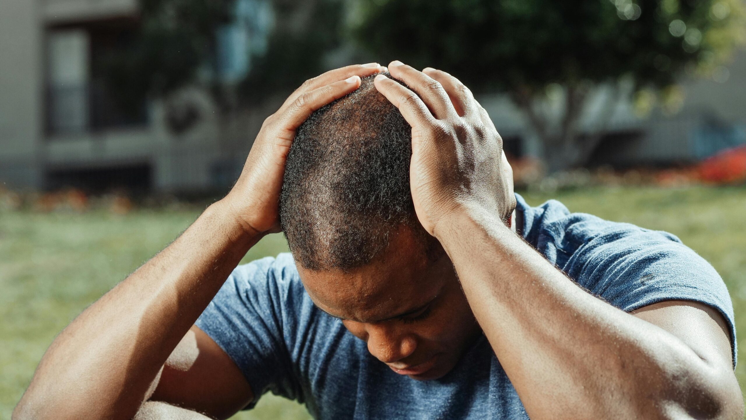 Man sitting with head in hands, overwhelmed by stress from loan app harassment in India