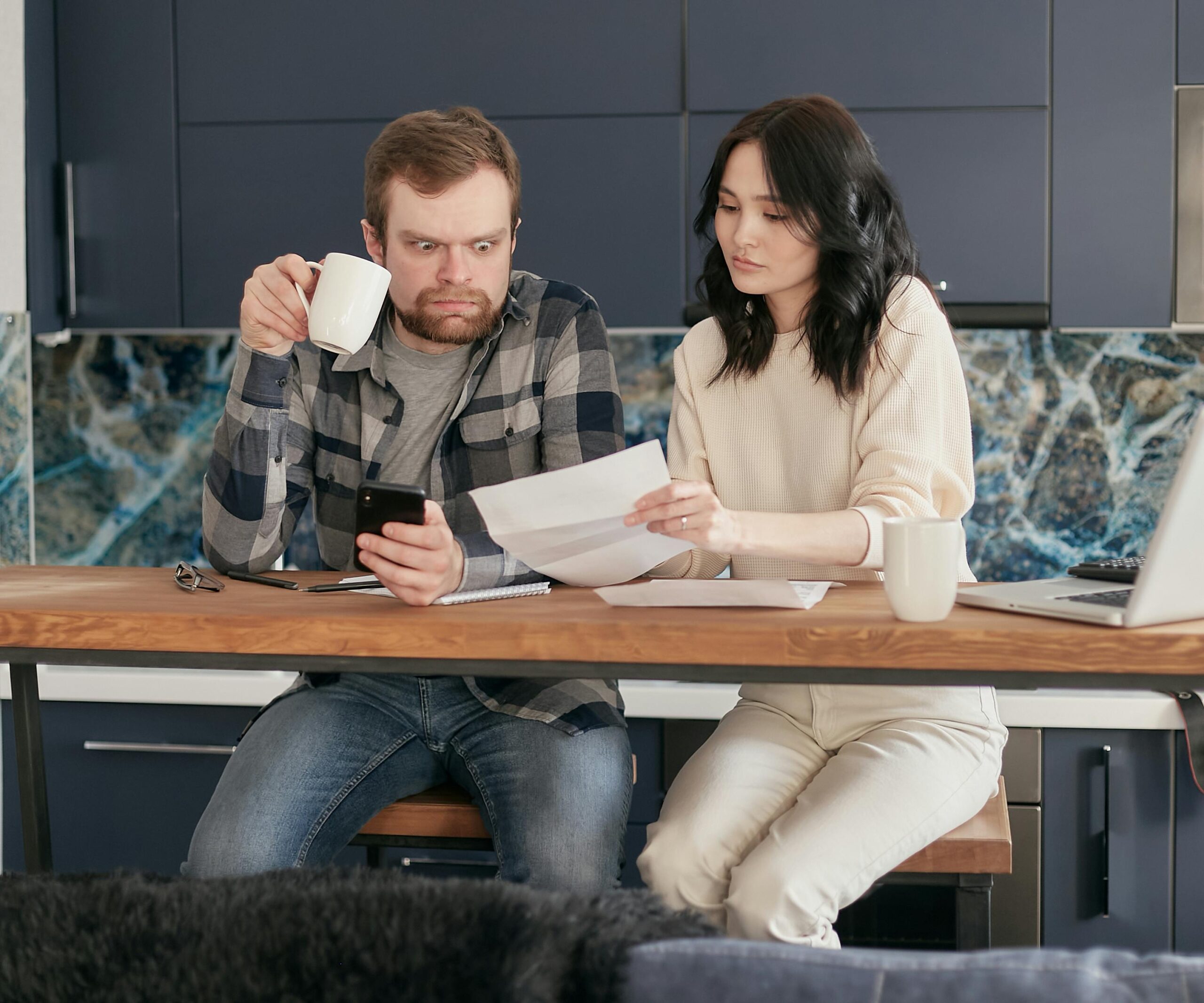 Worried man reviewing financial documents while holding phone — stressed about urgent loan decision in India