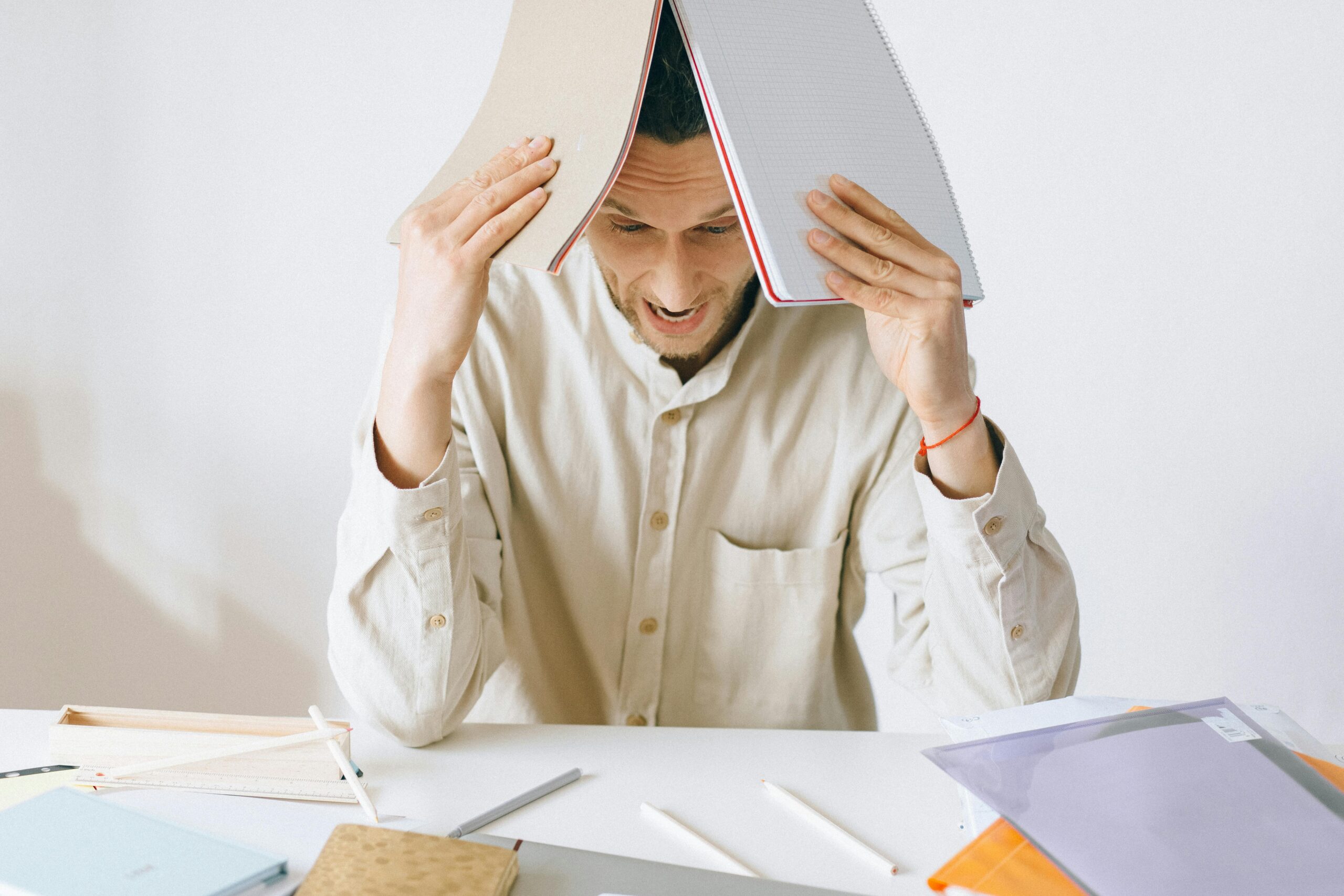 Businessman pausing at his desk before applying to a second loan app — running through the 5-question checklist
