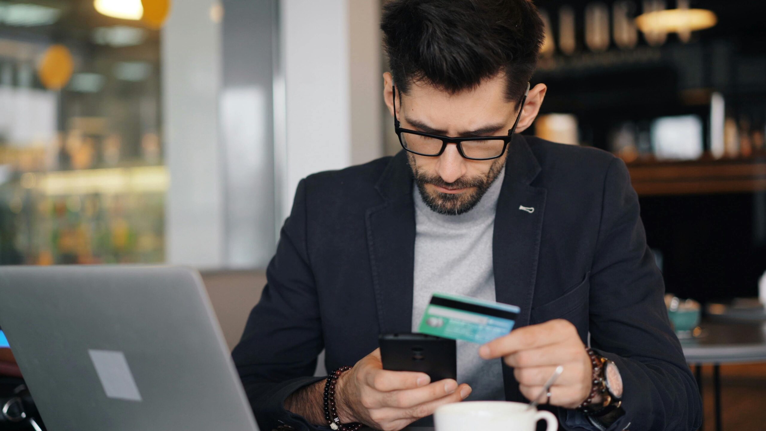 Man checking his phone and credit card after a loan was approved but money was not received in India