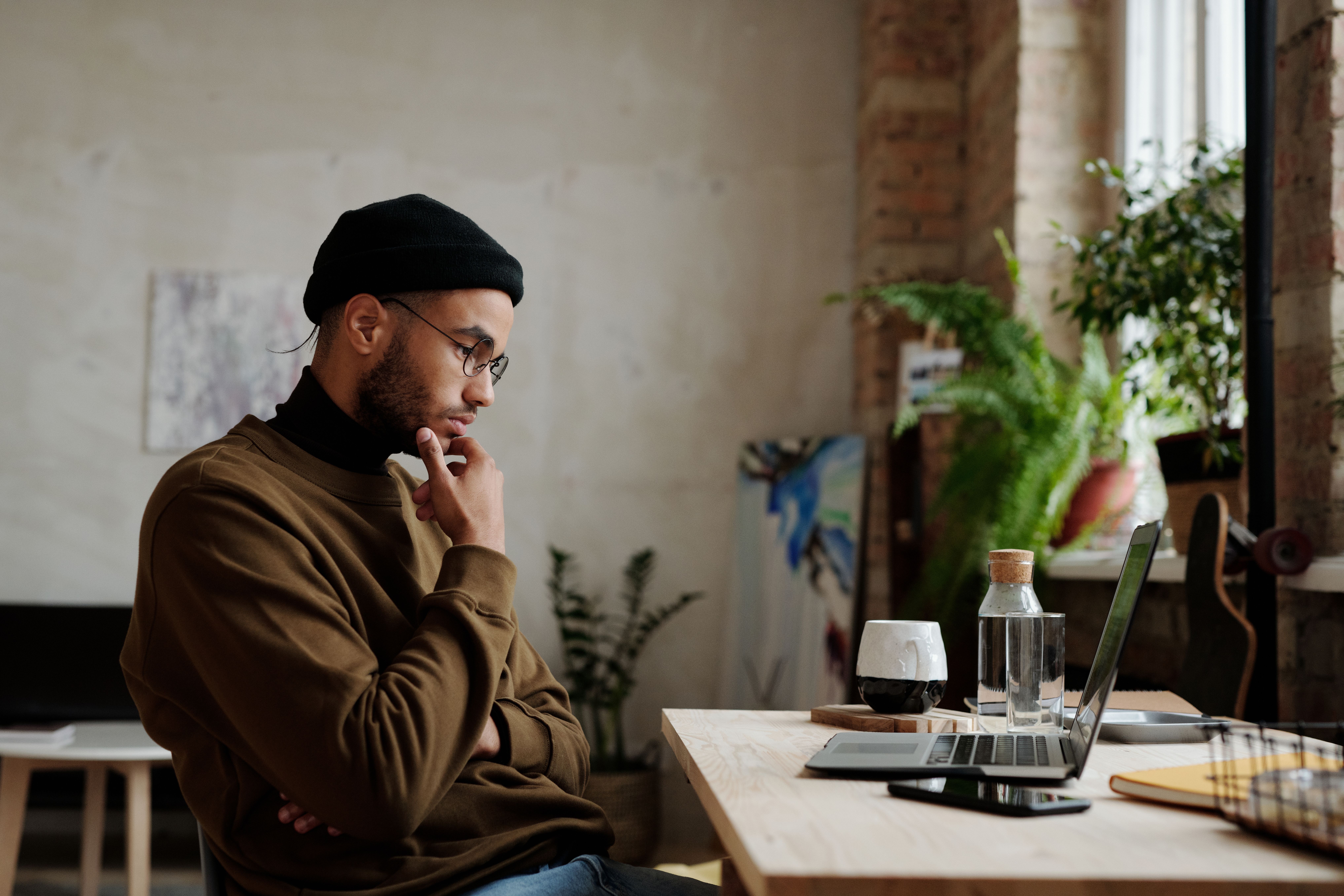Man thinking carefully before applying for a loan app in India — research and verify before clicking Apply