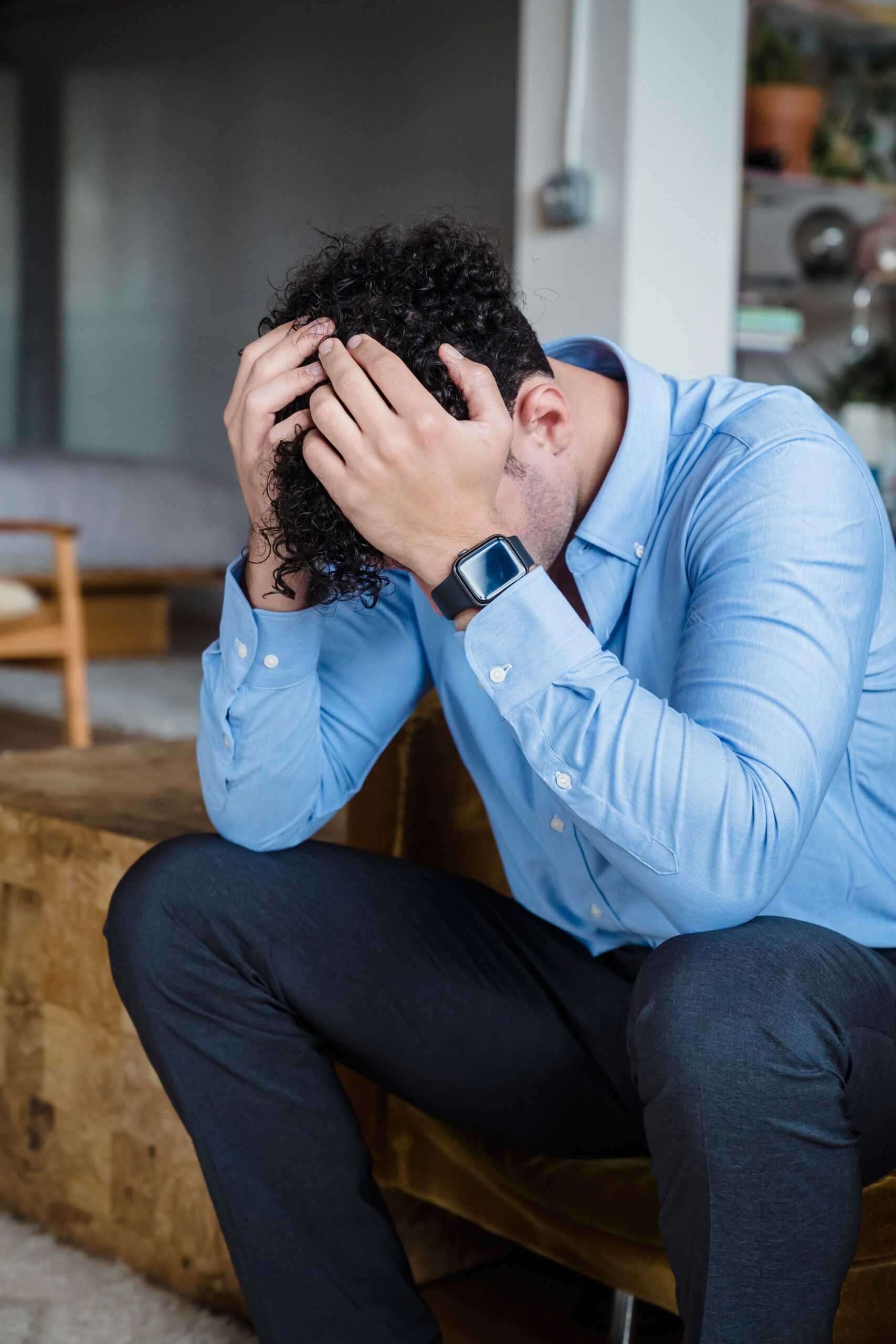Man sitting with hands on head in distress — the overwhelming feeling when you can't repay a loan app in India