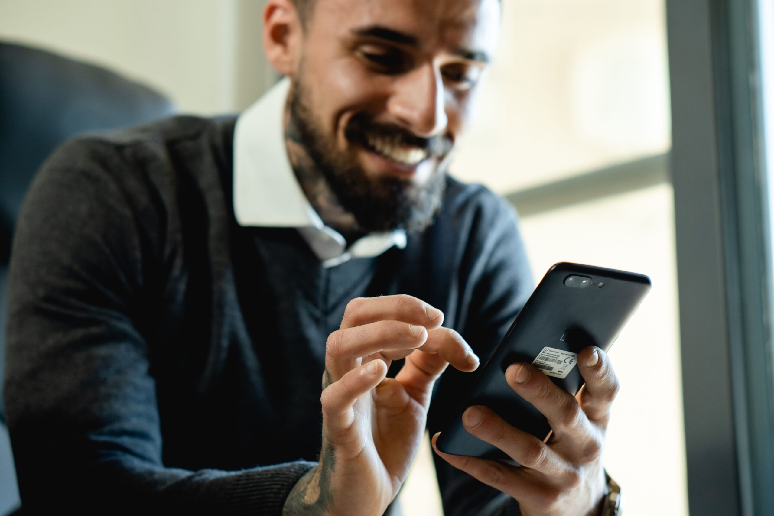 Smiling man checking his phone after finding a loan app suited to his income in India