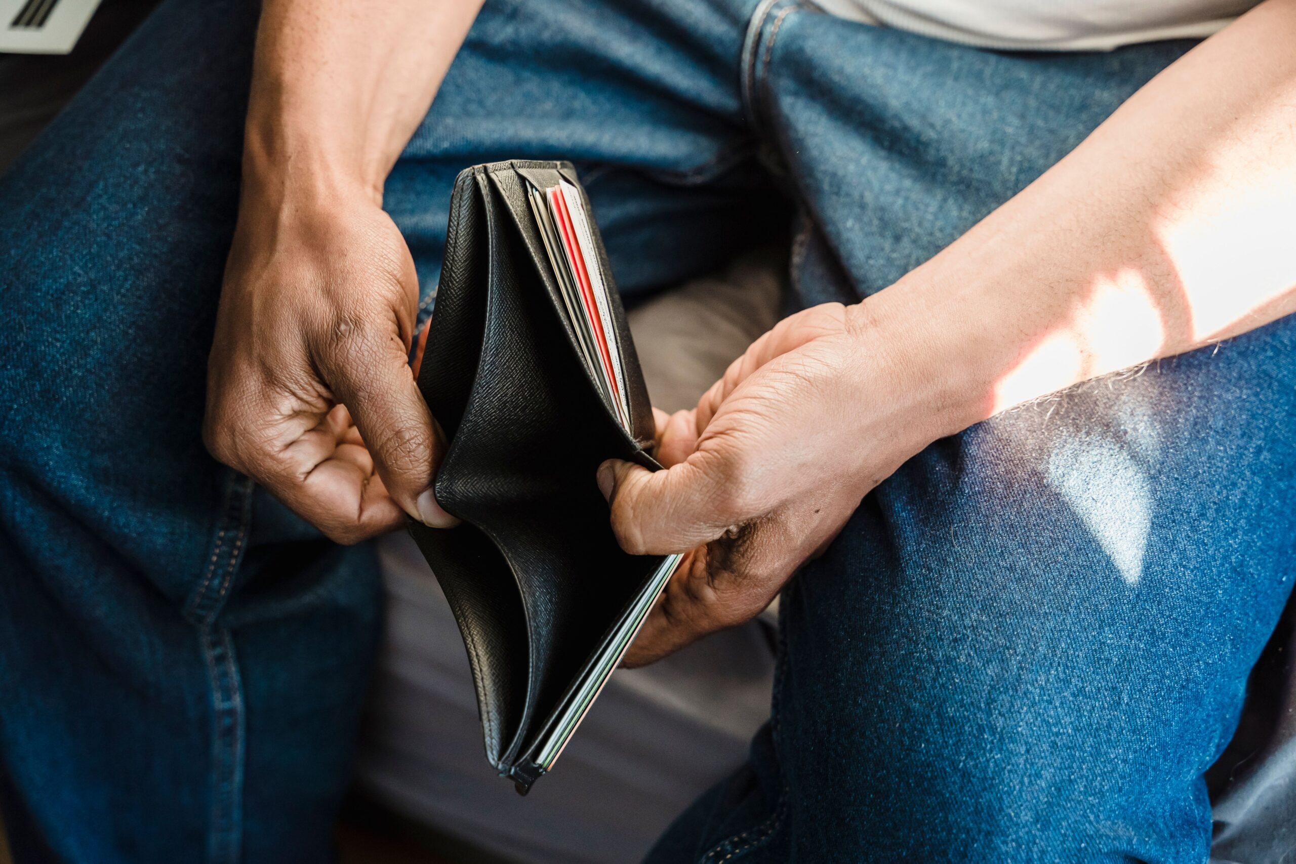 Man checking an empty wallet — the financial reality for many low-income salaried borrowers in India